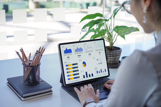 Asian financial analysts are analyzing business strategies in an investment bank, utilizing computers and processing big data on their dashboard.