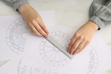 Astrologer using zodiac wheel for fate forecast at table, top view. Fortune telling