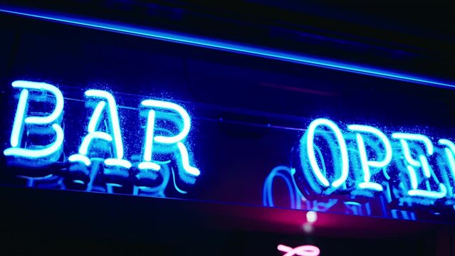 Illuminated BAR OPEN neon sign in vivid blue against the night sky.