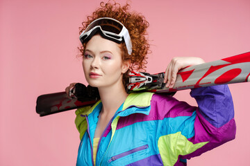 Portrait of beautiful curly redhaired woman, tourist wearing stylish vintage ski overalls