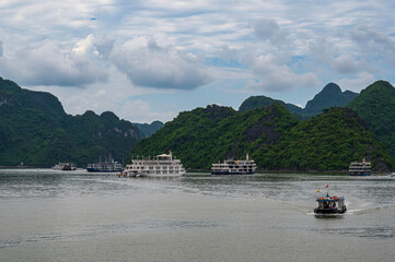 Fototapeta na wymiar Halong Bay, Vietnam, with cruise ships floating between the spectacular geological features of the UNESCO World Heritage site.