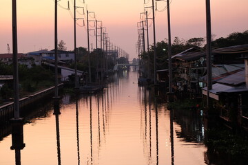 The atmosphere of the wooden houses along the canal in Bangkok in the evening looks as far as the eye can see.