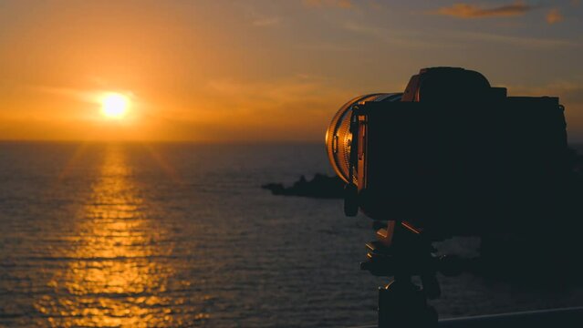 camera taking photos of beautiful sunset  