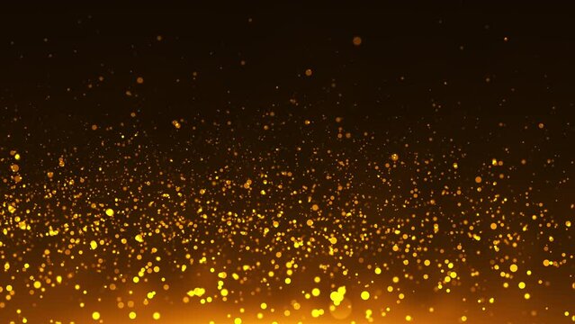Abstract gold particles of golden glitter going up with bright bokeh shine effect.