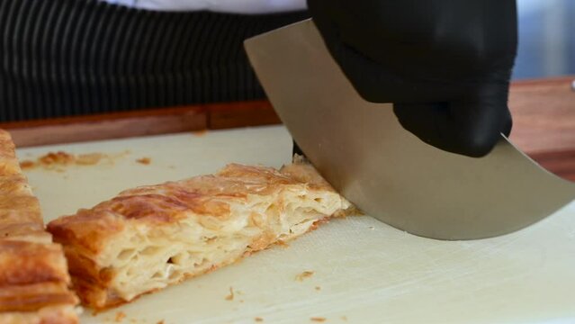 Chef cutting Kut or Kurt Borek on white cutting board