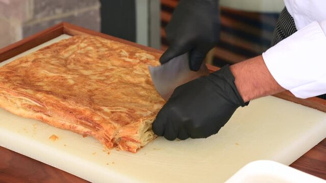 Chef cutting Kut or Kurt Borek on white cutting board