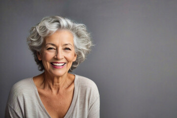 Hermosa mujer de 60 años de edad con el pelo gris riendo y sonriendo con dentadura perfecta. - obrazy, fototapety, plakaty