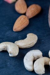 peeled cashew nuts on a black slate board, close-up