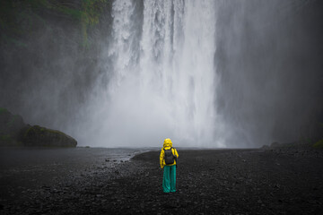 Skogafoss Waterfall with a model in front of the falls in Iceland