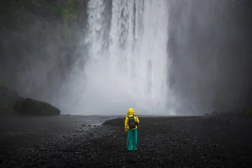 Tuinposter Skogafoss Waterfall with a model in front of the falls in Iceland © Nilton