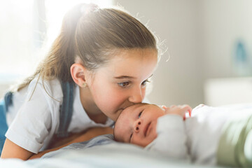sister on bedroom with newborn son at home