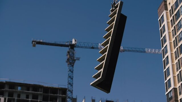 formwork is lifted on a tower crane at a construction site