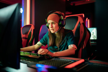 Professional female gamer wearing headphones participating in eSport tournament