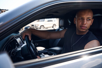 Handsome black driver trying to find some empty lot on parking