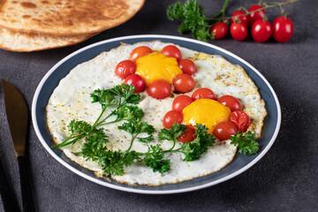 Scrambled eggs with cherry tomatoes in the shape of a flower, children's breakfast idea, closeup