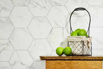 green lemon in basket above wood table near hexagon shape wall