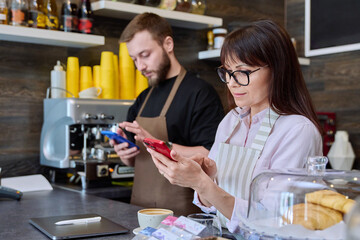 Team male and woman talking, working, using phone, coffee shop