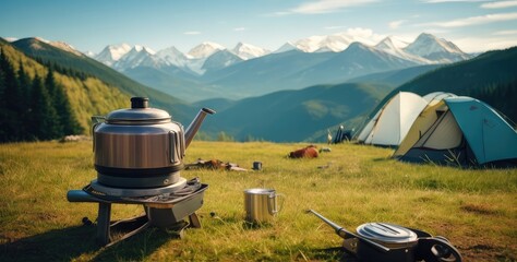 Camping gear by a fire kettle with a thermos and mountains in the distance, a concept for travel, and interests, - obrazy, fototapety, plakaty