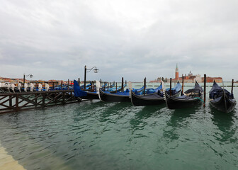 Fototapeta na wymiar gondolas moored in the Venetian lagoon Venice during high tide
