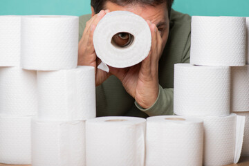 Man with a supply of toilet paper. Observation through a telescope made from a toilet paper roll.