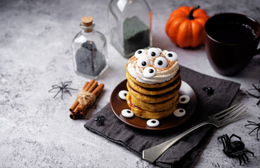 Pumpkin pancakes for Halloween holidays in the form of monster on a plate