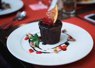 Tasty fruit dessert with berries. Delicious, colorful dessert decorated with fruits on a white plate while being served. Sweet dessert served for lunch in modern gourmet cuisine restaurant. fruit cake