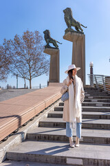 Young woman with white coat walking on Stone Bridge in Zaragoza