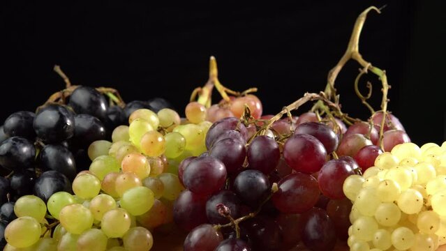 Fresh grapes of different varieties rotate as a background. Grape close up, concept winemaking, wine production, vine variety
