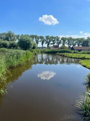Fototapeta na wymiar A river in the Netherlands with a reflection of a cloud