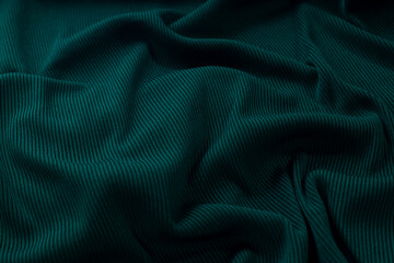The fabric lying in waves for the background is a deep green color