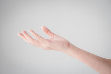 A beautiful woman's hand is isolated on a white background. Hand palm open and ready to help,...