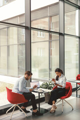 Two business colleagues working with documents together sitting in office.High quality photo