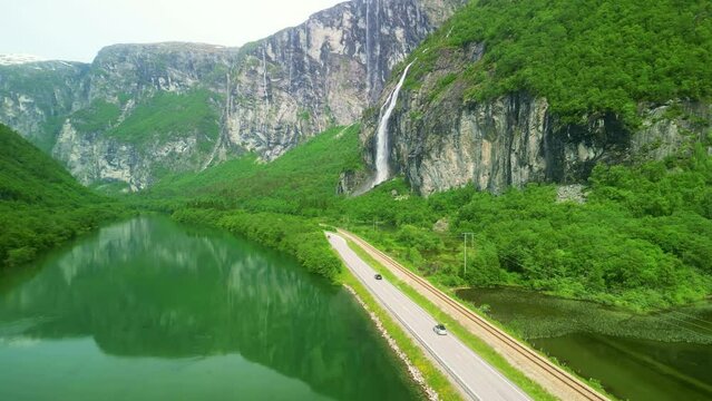Drone Norway. Car drive in canyon by Troll Wall Trollveggen mountain in Reinheimen national park. Waterfall by scenic drive. 