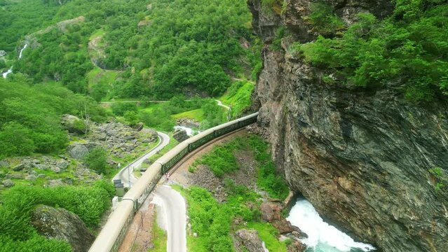 Drone Norway. Flamsbana train on Flam Railway in Flam, Norway. Mountains and waterfalls of Norway in summer. Famous train adventure for cruise ship tourists. 