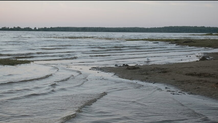 Beautiful lake landscape with waves on shore in evening. Creative. Waves of light breeze on shore...