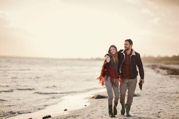 Young couple embracing each other while waking on the beach