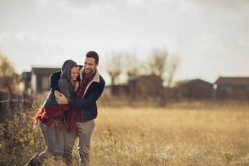 Young couple having a stroll on a grassland in the countryside