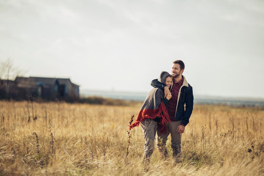 Young couple having a stroll on a grassland in the countryside