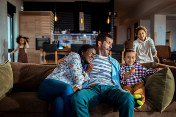 Young mixed family having fun on the couch at home