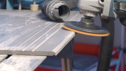 Worker polishing board with disc. Creative. Close-up of machine with disc for polishing surfaces. Carpenter polishes board or tile