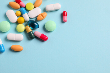 Many different pills on light blue background, flat lay. Space for text