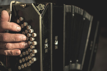 Closeup of a black bandoneon in the process of playing
