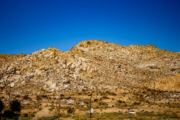 Sharp yellow rocky hills in california in front of a clear blue sky