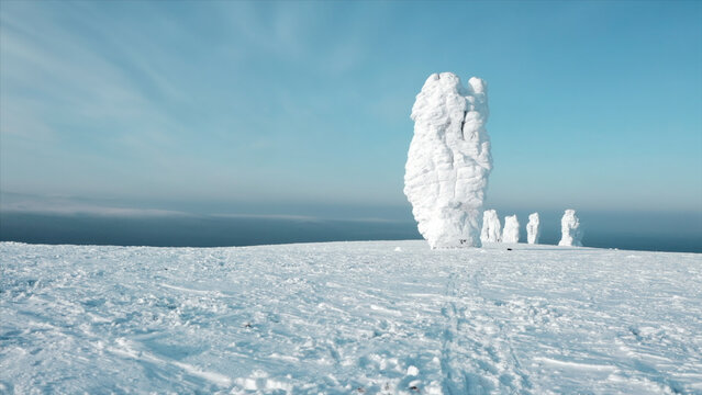 Landscape of plateau with snow-covered stone pillars. Clip. Hill with stone pillars on sunny winter day. Beautiful wonder of world - plateau with snowy stone pillars