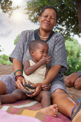 a bushmen San elderly woman from Central Kalahari, village New Xade in Botswana, holding her...