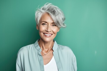 Mature woman winks playfully, her joy captured against a refreshing spearmint green. Enhanced by innovative generative AI for a contemporary touch. - obrazy, fototapety, plakaty