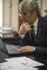 Business person talking on the phone, having a job interview, doing analysis with a tablet, and doing a job evaluation with a laptop.