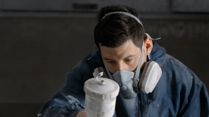 The employee carries out the repair. Creative. A man in work clothes and a puncher making a coating...