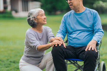 Obraz premium Asian people mature husband and wife, one in wheelchair, savoring peaceful outdoor moments in garden. Love and togetherness in midst of nature beauty. long live togetherness, valentine, insurance