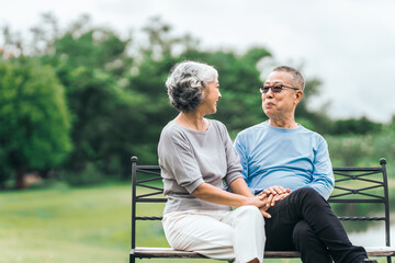 Asian people mature husband and wife, seated on chairs, elderly couple, seated in the park on comfortable chair, deep love and lifelong. Elderly Love Senior Couples, long life togetherness